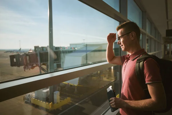 飛行機で旅行する男 空港で待っている間に搭乗券を保持する乗客 — ストック写真