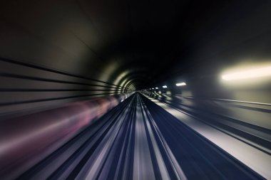 Railroad track in underground tunnel in blurred motion. Point of view from train