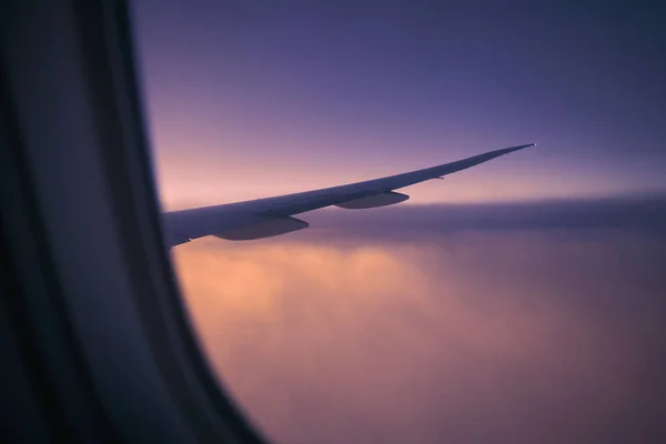 새벽에 비행하는 비행기 창문에서 바라보라 선택적으로 항공기 날개에 초점을 맞추다 — 스톡 사진