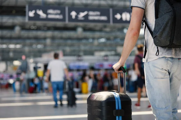 飛行機で旅行する スーツケースを持った男の手にフォーカス 空港ターミナルを通ってチェックインに向かって荷物を持って歩く旅行者 — ストック写真