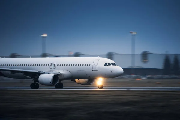 夜間空港滑走路を離陸中の商業機 ぼやけた動きの平面 — ストック写真