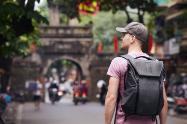 Meşgul Asya caddesinde yürüyen bir gezgin. Hanoi, Vietnam 'daki Old Quarter' da sırt çantalı bir adam..