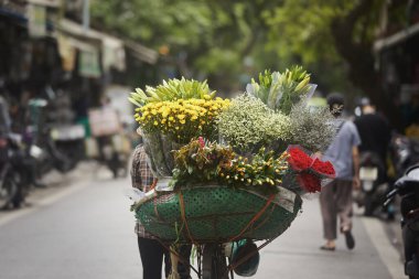 Hanoi, Vietnam 'daki Old Quarter' da bisikletli sokak çiçekçisinin arka manzarası.