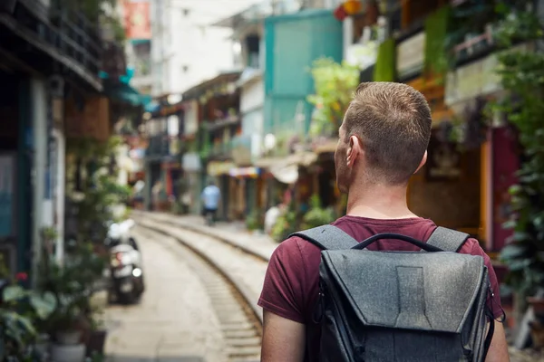 背着背包穿过狭窄的火车街的人 河内越南居民楼之间的铁路轨道 — 图库照片