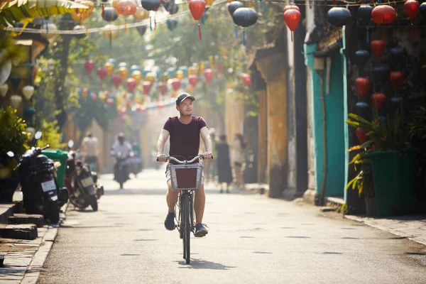 在老城区骑自行车的游客 越南海安古城街道装饰着传统灯笼 — 图库照片