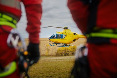 İlk yardım ekipleri acil tıbbi servis helikopterine bakarken arkadan bakıyorlar. Tema kurtarma, acil durum ve sağlık hizmetleri.