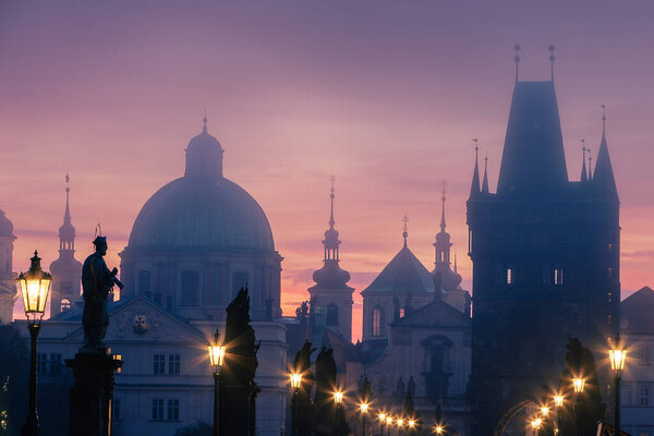 Misty mornig from Charles Bridge. Colorful sunrise over towers of Prague, Czech Republic