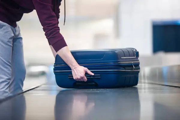 Passenger Traveling Plane Picking Blue Suitcase Conveyor Belt Airport Arrivals — Stock Photo, Image
