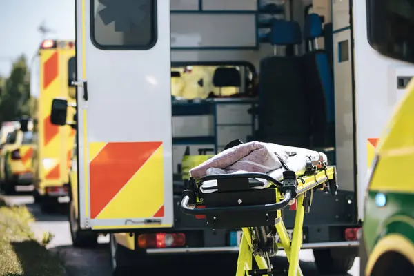 伸缩者在开着的救护车后面准备着 市区街道上的紧急医疗服务队 主题是救援 紧急救援和医护 图库图片