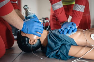 Diriltme sırasında doktor ve sağlık görevlilerinin elleri. Suni teneffüs eğitimi sırasında acil servis ekibi. Tema kurtarma, acil durum ve sağlık hizmetleri.