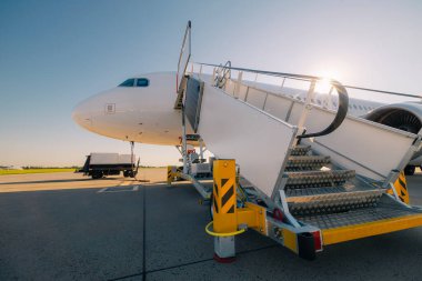 Mobil merdiven güneşli bir günde havaalanında uçağa binmek için hazır.