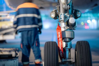 Aircraft nose wheel with red flag Remove Before Flight. Selective focus on airplane at airport.
