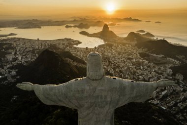 Rio de Janeiro, Brezilya - 21 Mart 2023: Kurtarıcı İsa Corcovado Dağı 'nın tepesinde gün doğumunda ufuk çizgisinde Şekerleme Dağı ile birlikte.