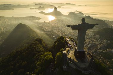 Rio de Janeiro, Brezilya - 21 Mart 2023: Kurtarıcı İsa Corcovado Dağı 'nın tepesinde gün doğumunda ufuk çizgisinde Şekerleme Dağı ile birlikte.