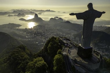 Rio de Janeiro, Brezilya - 21 Mart 2023: Kurtarıcı İsa Corcovado Dağı 'nın tepesinde gün doğumunda ufuk çizgisinde Şekerleme Dağı ile birlikte.