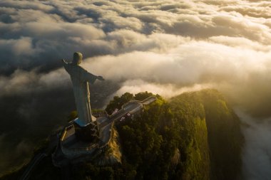 Rio de Janeiro, Brezilya - 11 Nisan 2024: Güneş doğarken Corcovado dağının tepesindeki Kurtarıcı İsa heykelinin dramatik manzarası.