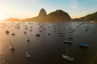 Brezilya 'nın Rio de Janeiro şehrinde Gündoğumunda Ufukta Sugarloaf Dağı ile Botafogo Körfezi' nde birçok küçük tekne