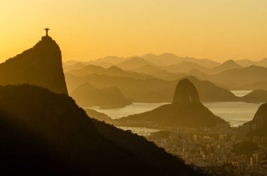 Rio de Janeiro şehrinde sıcak gün doğumu Güzel Corcovado ve Sugarloaf Dağları manzaralı