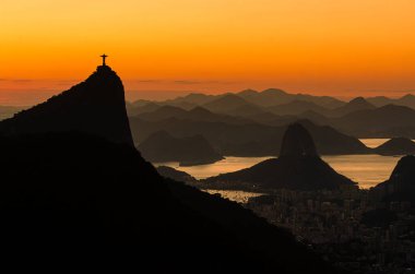 Rio de Janeiro şehrinde sıcak gün doğumu Güzel Corcovado ve Sugarloaf Dağları manzaralı