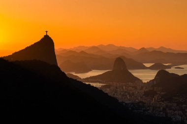 Rio de Janeiro şehrinde sıcak gün doğumu Güzel Corcovado ve Sugarloaf Dağları manzaralı