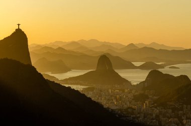 Rio de Janeiro şehrinde sıcak gün doğumu Güzel Corcovado ve Sugarloaf Dağları manzaralı