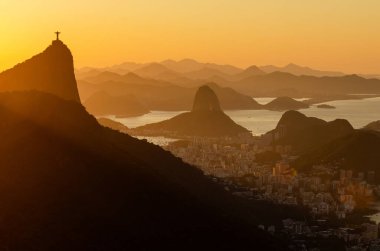 Rio de Janeiro şehrinde sıcak gün doğumu Güzel Corcovado ve Sugarloaf Dağları manzaralı