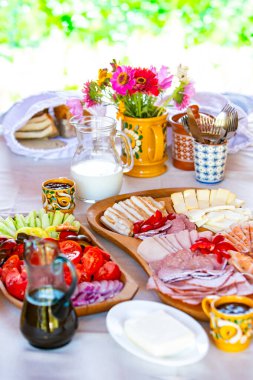 Kahvaltı tabakları, taze çiçekler ve renkli süslemelerle dolu canlı bir masa..