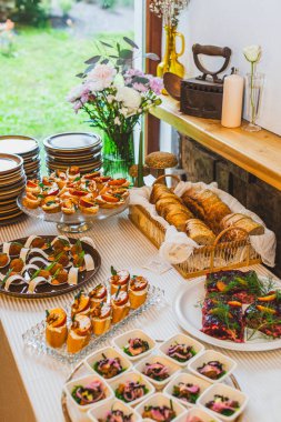 Aperatifleri, ekmekleri, çiçekleri ve kırsal bir ambiyansı olan güzel bir masa..