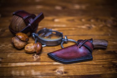 El yapımı bir bıçak ve kılıf, kırsal bir arka planda klasik açık hava ekipmanları sergiliyor..