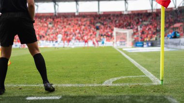 Futbol sahasının köşesinde vurucu hakem ve bayrak