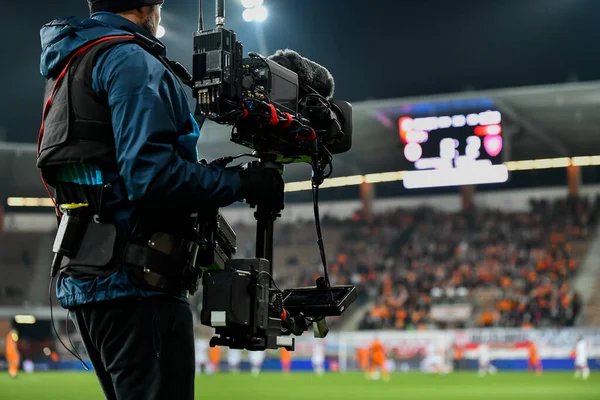 Futbol maçında oyun sahasının arkasındaki kameraman.