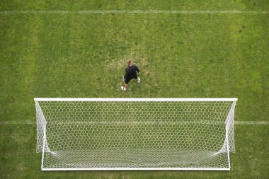 Soccer goalkeeper in front of goal - view from above