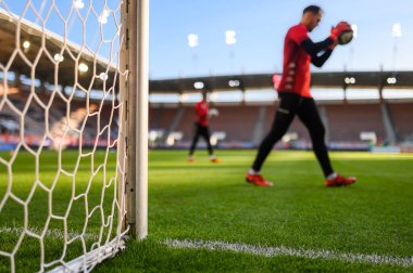 Net and the post in the football goal at the  stadium and goalkeeper in the background.