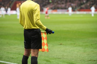 Futbol stadyumunda maç sırasında bayrak taşıyan bir futbol hakemi..
