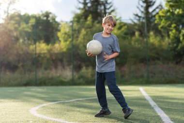 Futbol antrenmanları sırasında genç bir çocuk. 