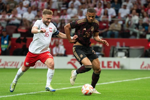 WARsaw, POLAND - 16 Haziran 2023 Polonya-Almanya maçı 1: 0. Eylemde Jakub Blaszczykowski Kuba (L) Malick Thiaw (R).