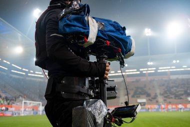 Yağmur altında futbol maçı sırasında oyun sahasının arkasındaki kameraman