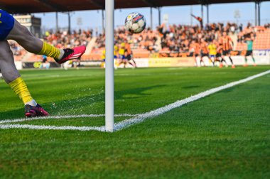 Futbolcu köşeyi dönüyor. Futbol maçında oyuncunun bacakları ve topun ayrıntıları.