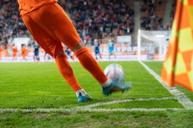 Futbolcu köşeyi dönüyor. Futbol maçında oyuncunun bacakları ve topun ayrıntıları.