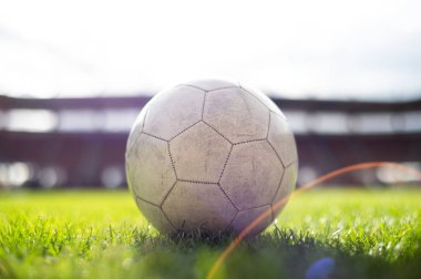 Stadyumdaki çimlerin üzerinde duran beyaz futbol topu.