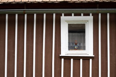 Güzel eski ahşap pencere ve ahşap kahverengi ev duvarı.
