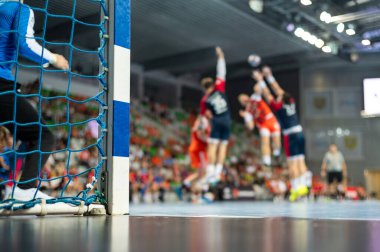 Hentbol kale direğinin ayrıntıları ve arka planda hentbol maçı