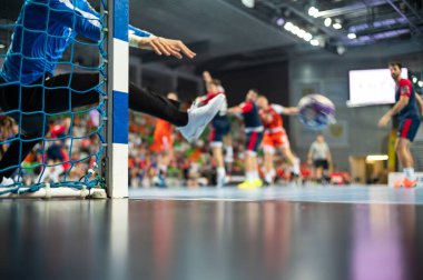 Hentbol kale direğinin ayrıntıları ve arka planda hentbol maçı