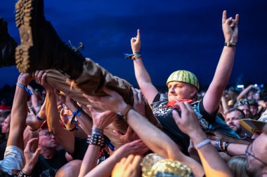 JAROCIN, POLAND - 18 Temmuz 2025: 2025 Jarocin Festivali Rock müzik ile. Seyircilerin ellerinde sörf yapan adam.. 
