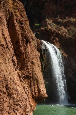 Faslı genç adam yüksek kayalıklardan bir şelalenin altındaki suya atlıyor..
