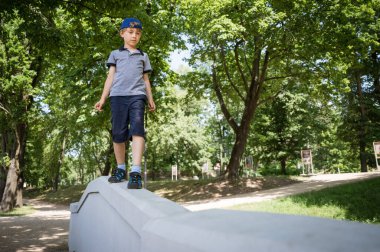 Genç çocuk güneşli bahar gününde parkta egzersiz yapıyor.