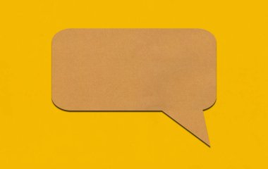 Sarı kağıtta kahverengi kağıt konuşma balonu. Reklam tasarımı için kopyalama alanı olan metin kutusu boş.