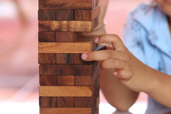 Wooden puzzle game align vertically and finger of child in toy concept or related business concept.