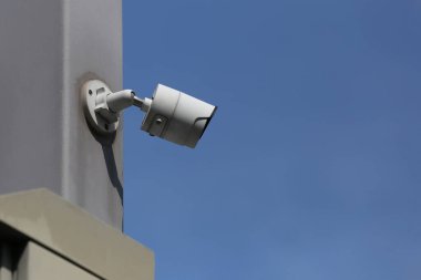 Mavi gökyüzü arkaplanı üzerindeki CCTV aracı, güvenlik sistemleri için ekipman ve tasarım için kopyalama alanına sahip.