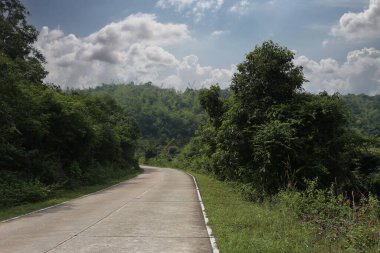 Gündüz vakti arka planda mavi gökyüzü manzaralı beton yol ve arabasız boş yol
